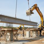 Installation d'une longrine en béton armé sur des points d'appui dans un chantier de construction.