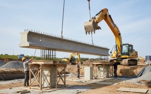 Installation d'une longrine en béton armé sur des points d'appui dans un chantier de construction.