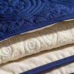 Détail d'un tissu matelassé montrant ses couches et motifs de piqûre